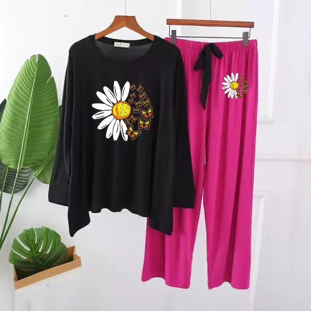 Women's loungewear set with black long-sleeve top and fuchsia pink pants, daisy print.
