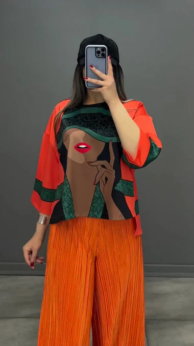 Orange silk-printed co-ord set with wide-leg pants and long-sleeve graphic top