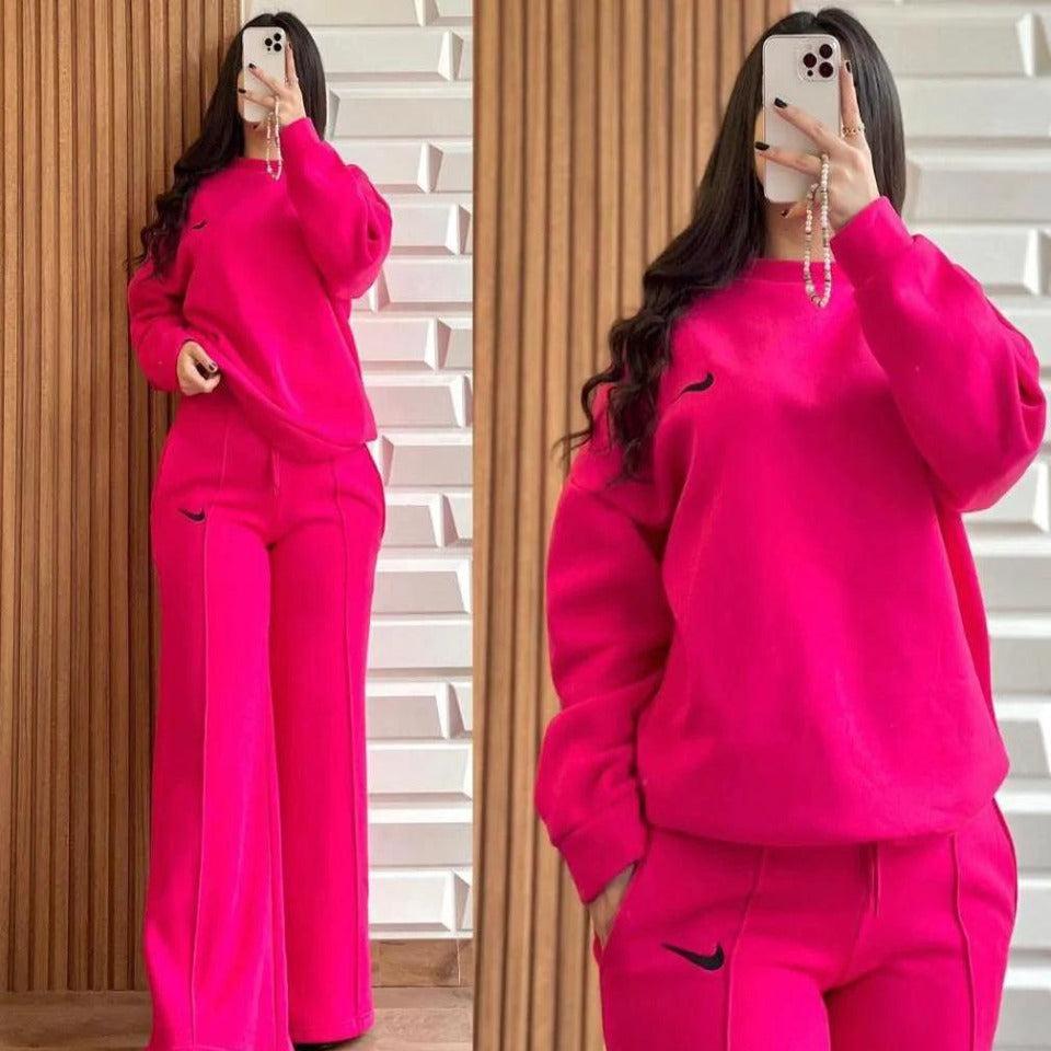 Pink two-piece lounge set with hooded sweatshirt and wide-leg pants, drawstring waist.