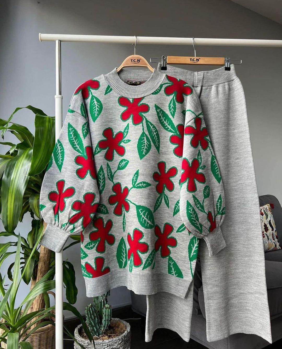 Green leaf knit sweater with red and green floral motifs and matching grey trousers