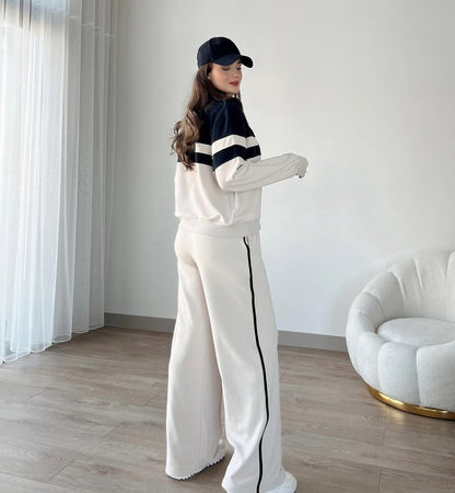 Zip-up track jacket and wide-leg pants set, side view with white panel stripes