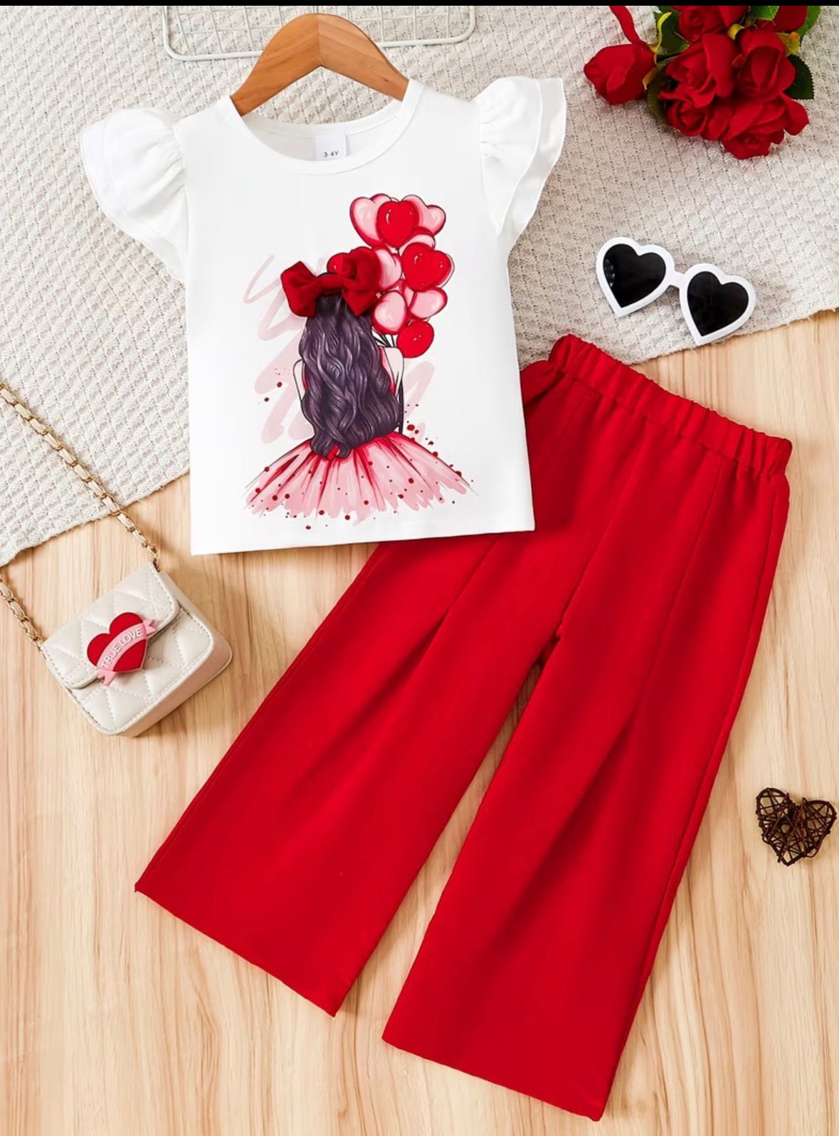 Girls red-and-white outfit set: white puff-sleeve top with hair-and-hearts print, red pants