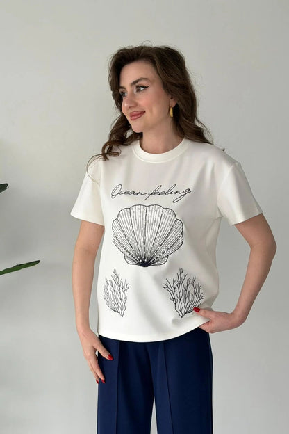 Printed cord set with white shell graphic T-shirt and navy blue wide-leg pants, close-up