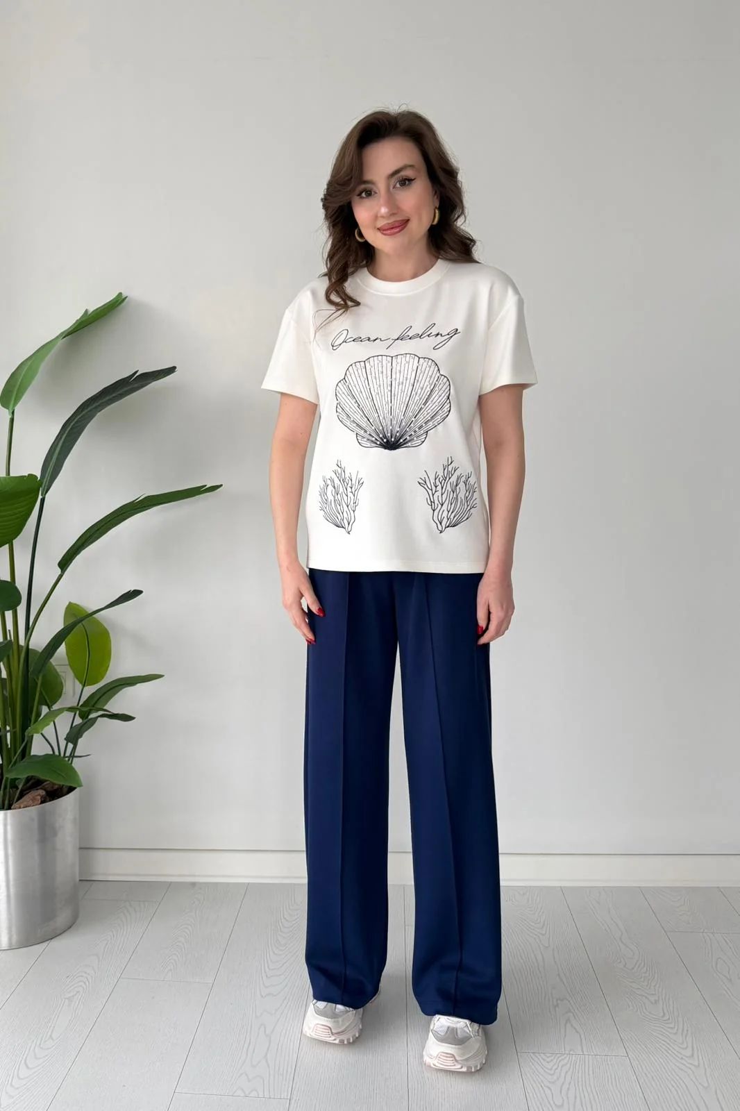 Printed cord set with white shell graphic T-shirt and navy blue wide-leg pants, full body