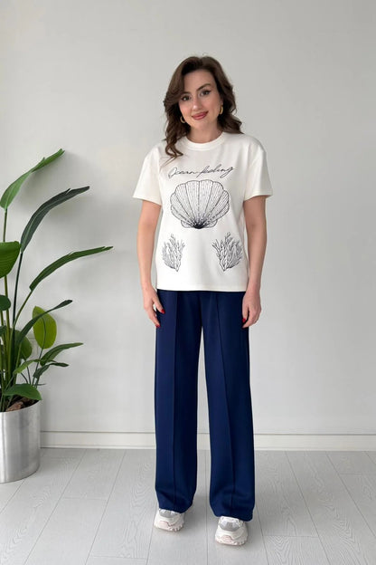 Printed cord set with white shell graphic T-shirt and navy blue wide-leg pants, full body
