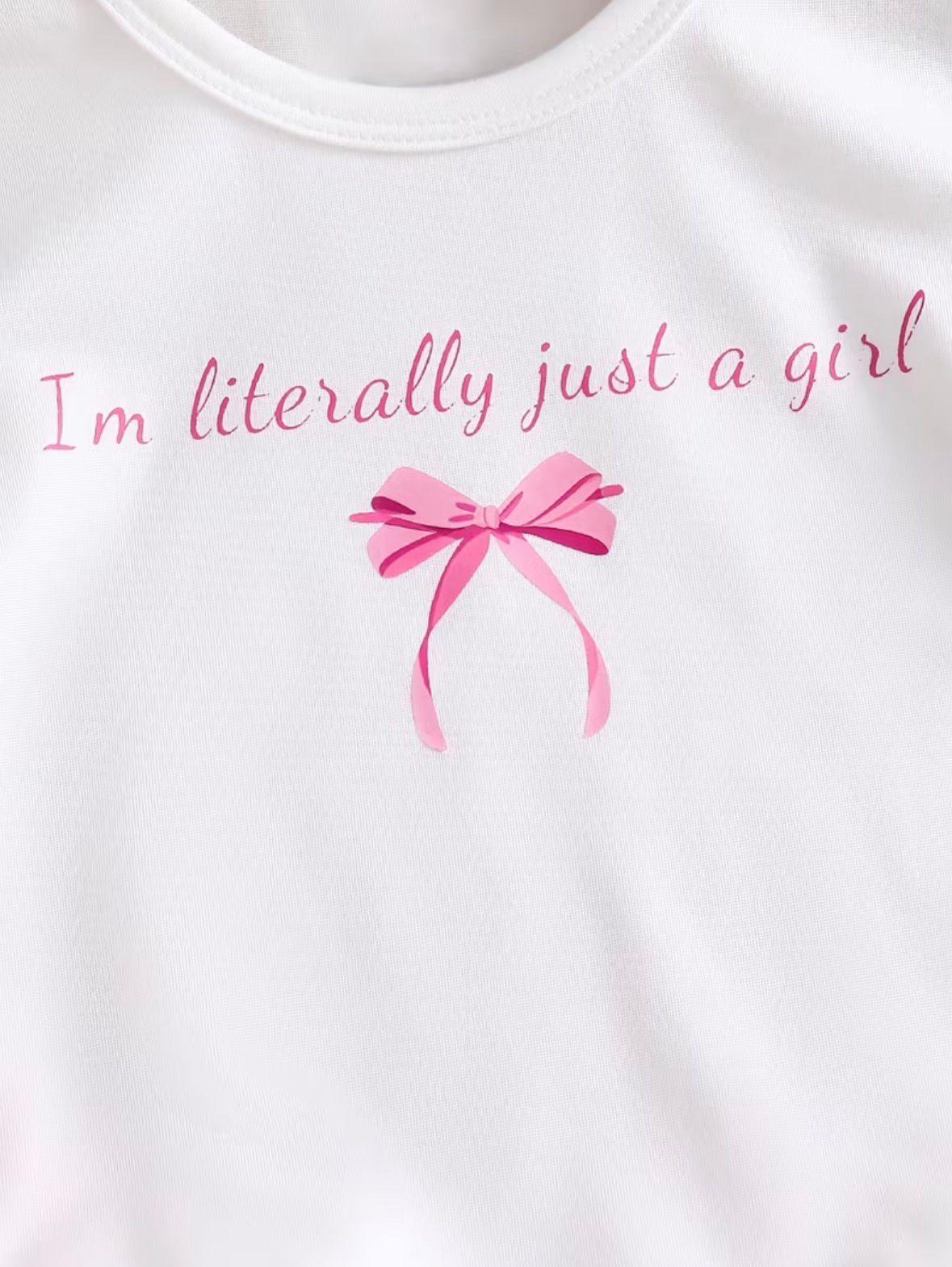 White T-shirt with pink text and bow graphic at center
