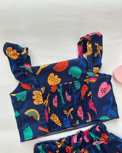 Navy tiered skirt with gathered smocked bodice and colorful fruit and rainbow print