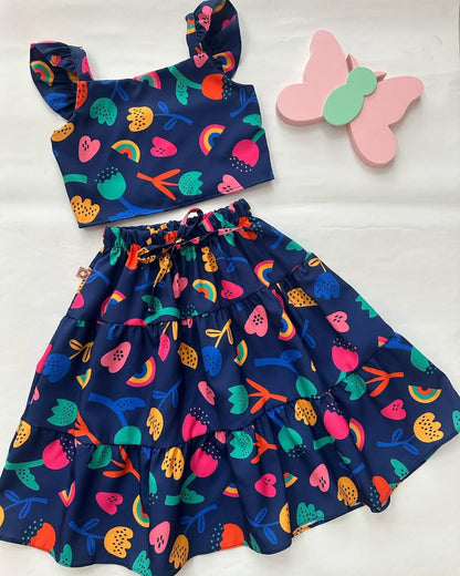 Navy tiered skirt with elastic waist and playful fruit, animal, and rainbow print