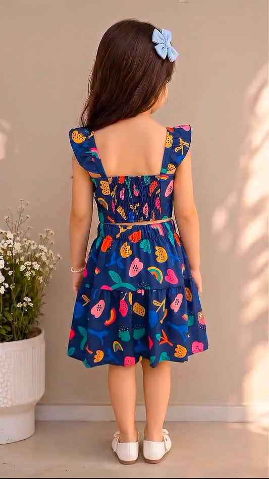 Back view of kids' blue fruit-print skater skirt with ruffled straps and tied waist bow
