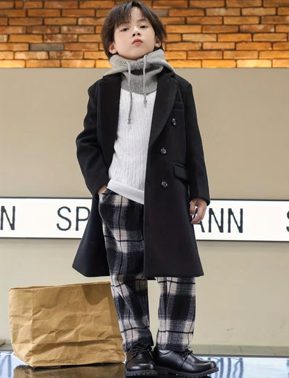 Vintage black trench coat with notched lapels and double buttons, worn over plaid pants