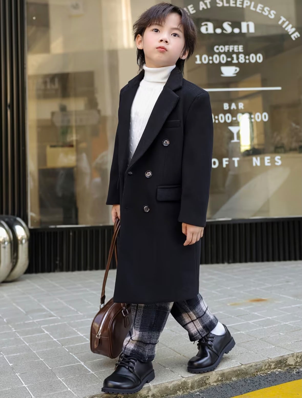 Vintage black trench coat with double-breasted front and flap pockets, side step view