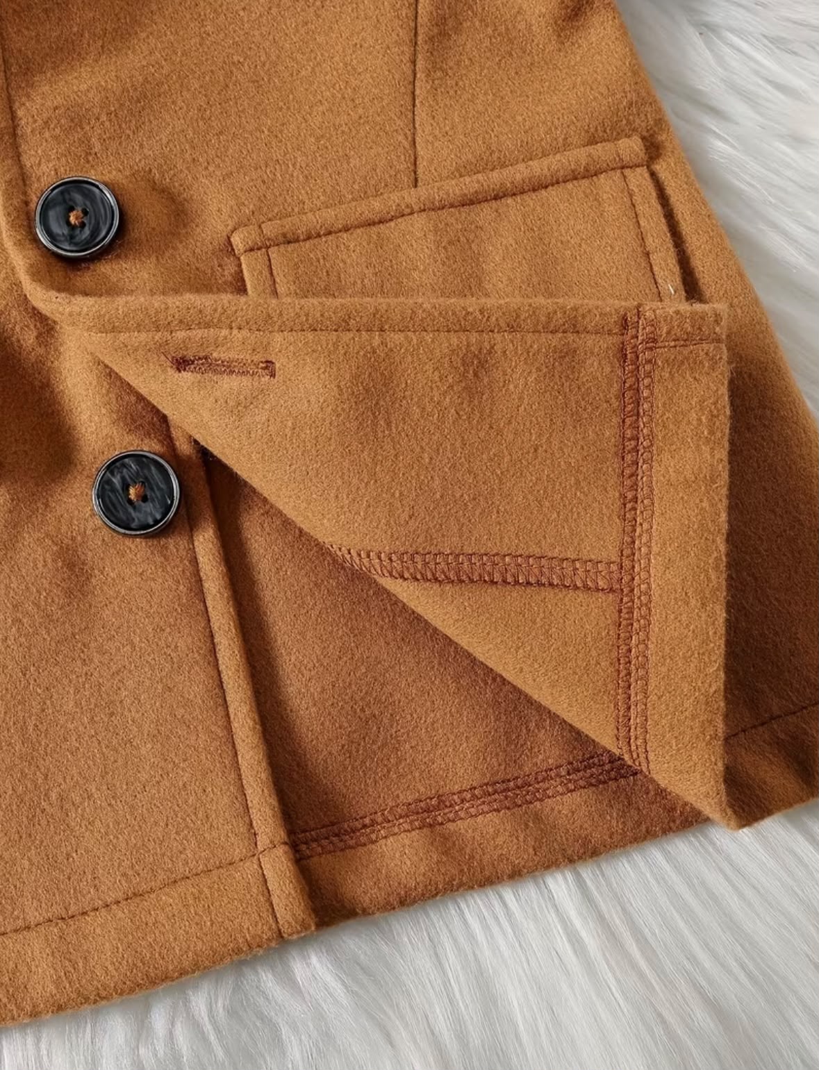 Camel coat pocket and inner lining detail with round button