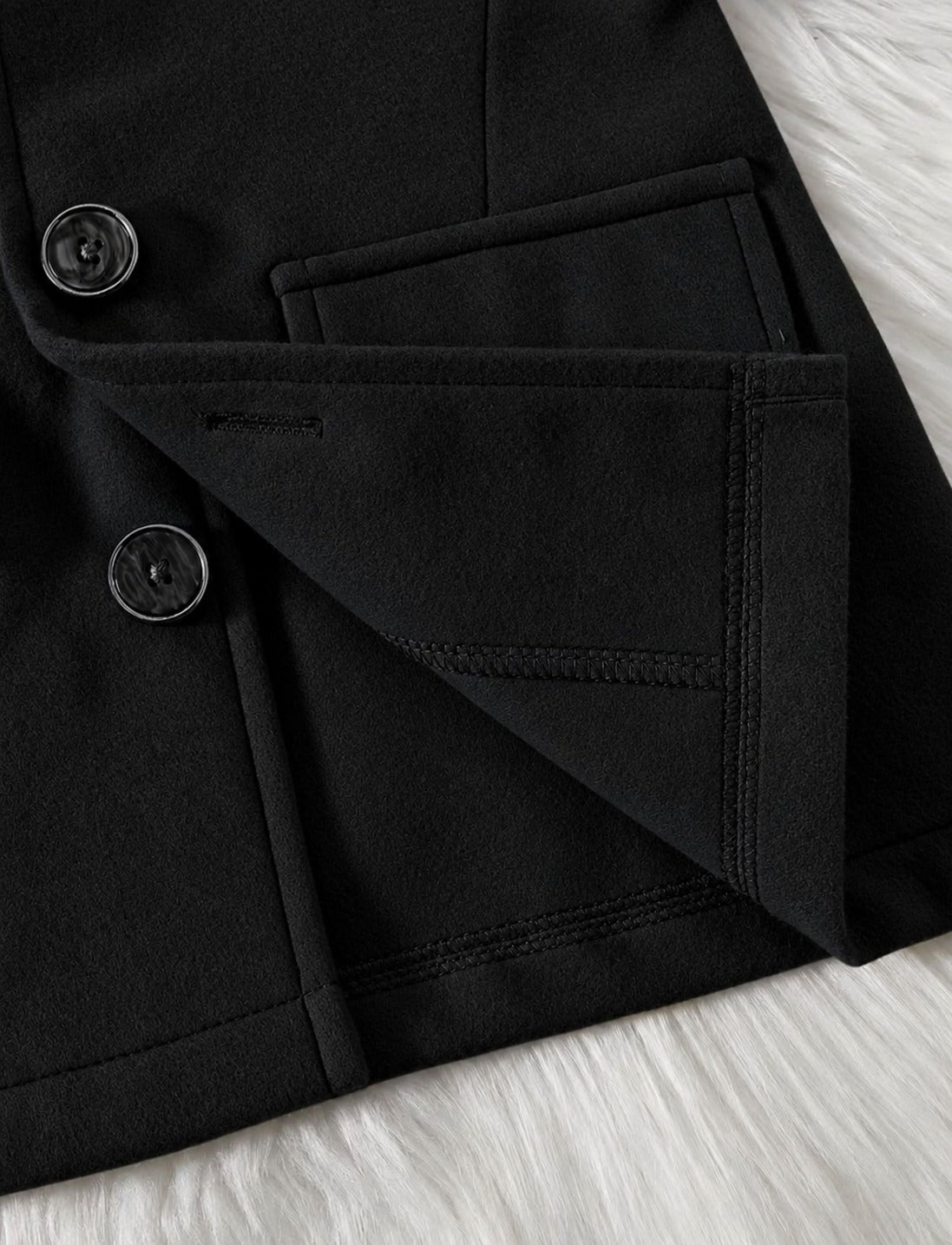 Black hooded coat sleeve cuff with round buttons and stitched flap pocket