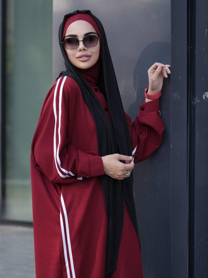 Maroon abaya dress with white stripe sleeves, button front, paired with black hijab and sunglasses
