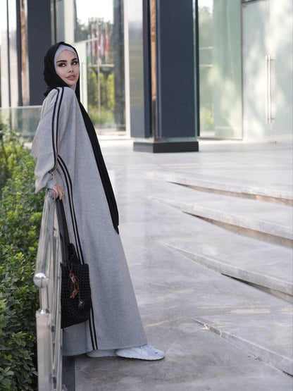 Grey abaya dress with black trim and draped sleeves, paired with black hijab