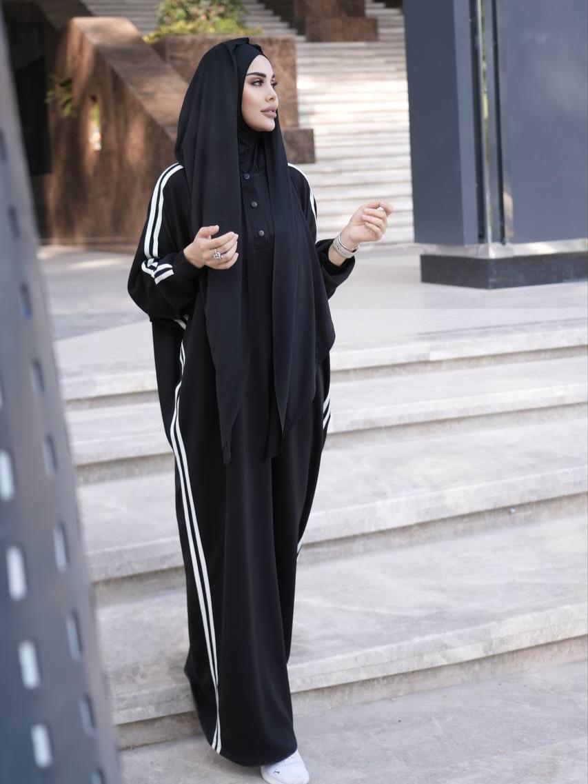 Black abaya dress with white stripe accents, button front, paired with black hijab