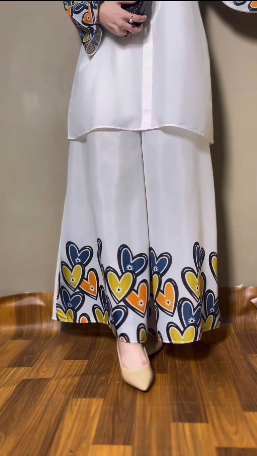 Wide-leg palazzo in white with blue-yellow-heart print hem; matching shirt visible