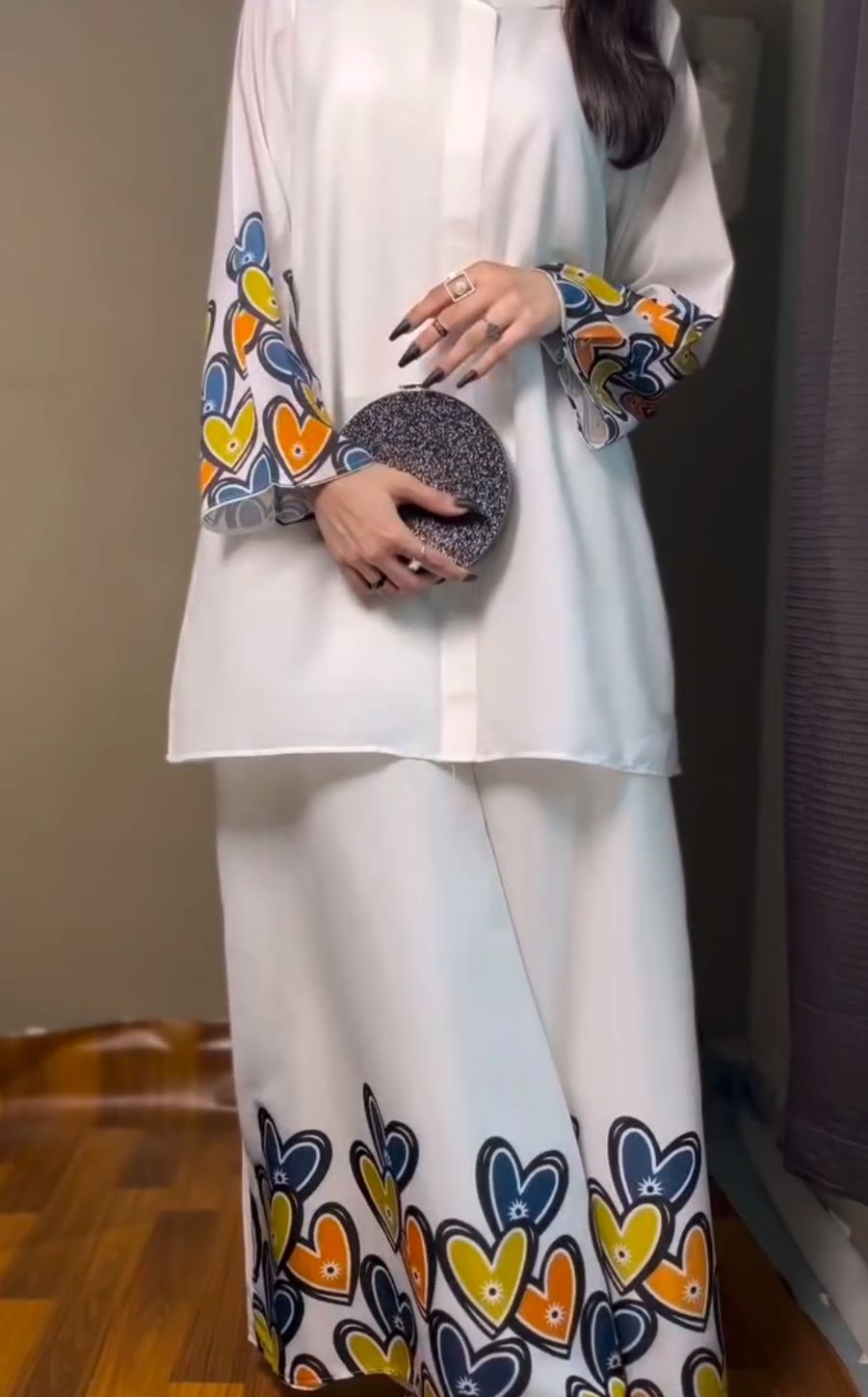 White printed shirt with heart motifs on sleeves; wide-leg palazzo with heart hem