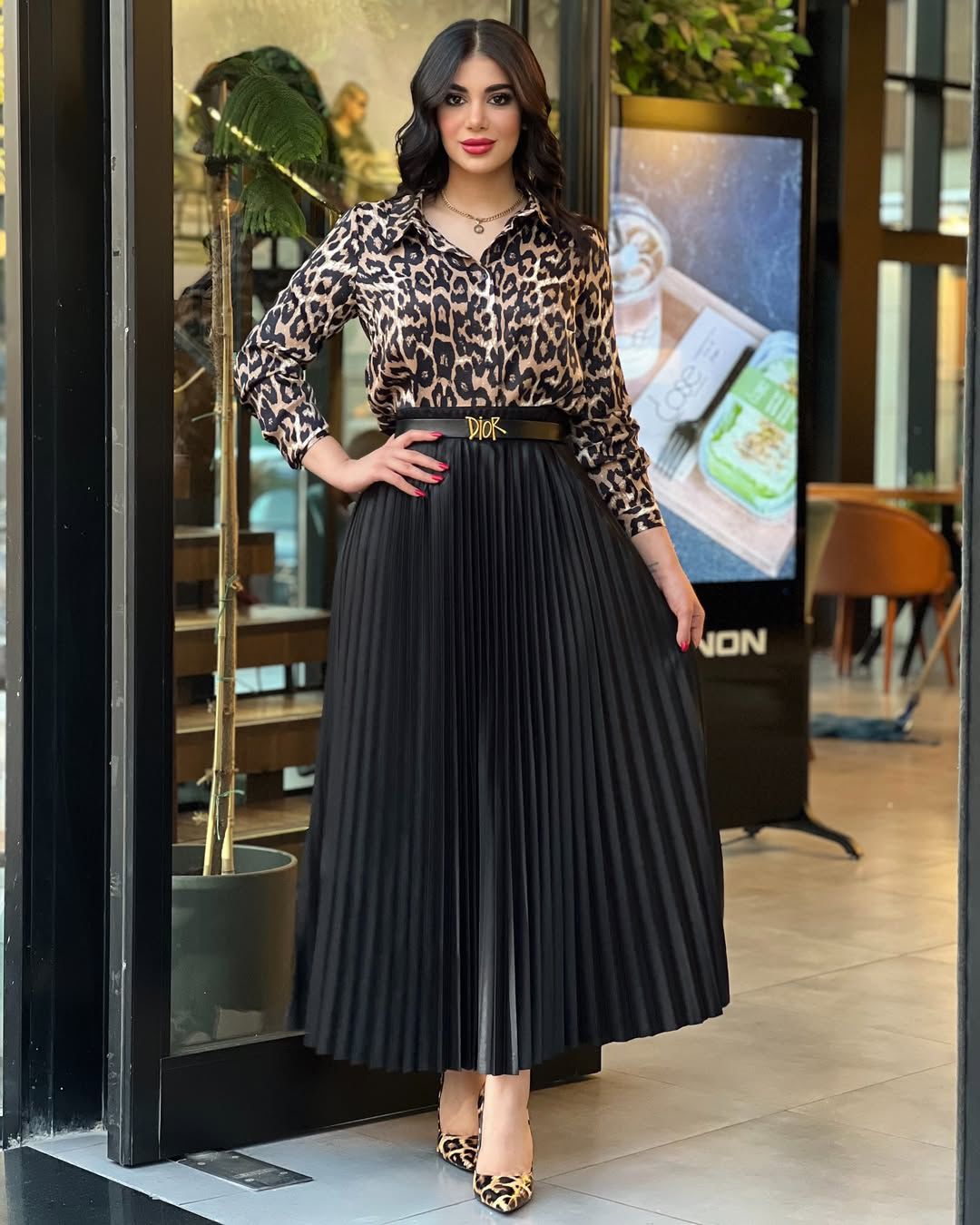 Tiger-print top with black pleated midi skirt and black waist belt