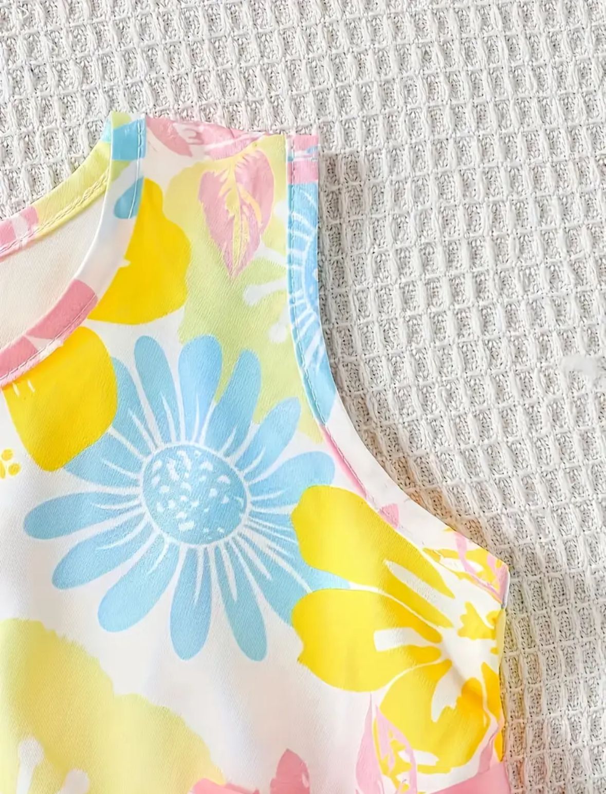 Girls sleeveless floral dress, pastel yellow and blue flower print, curved neckline