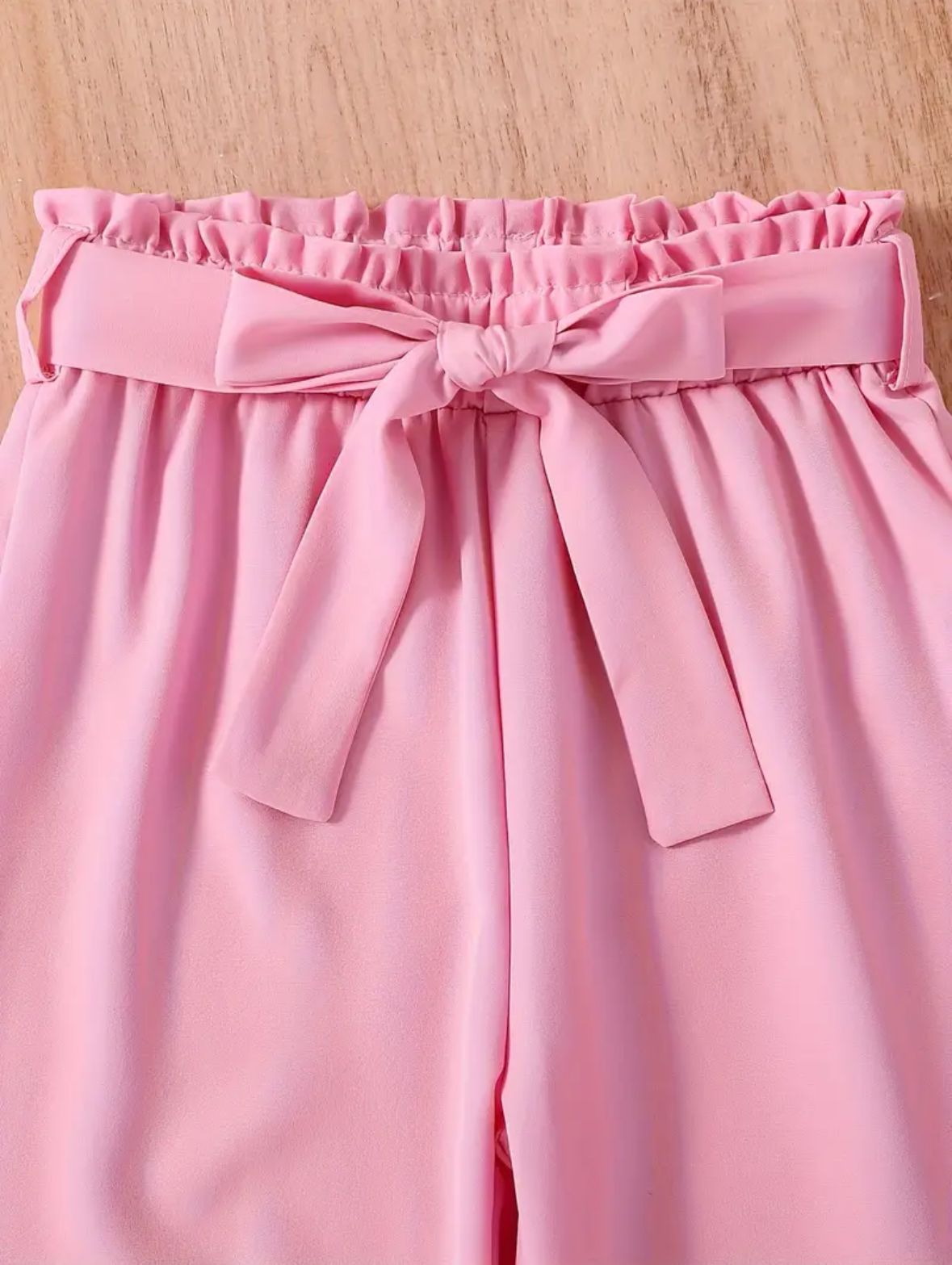 Pink pants with elastic waist, ruffled waistband and tied bow detail