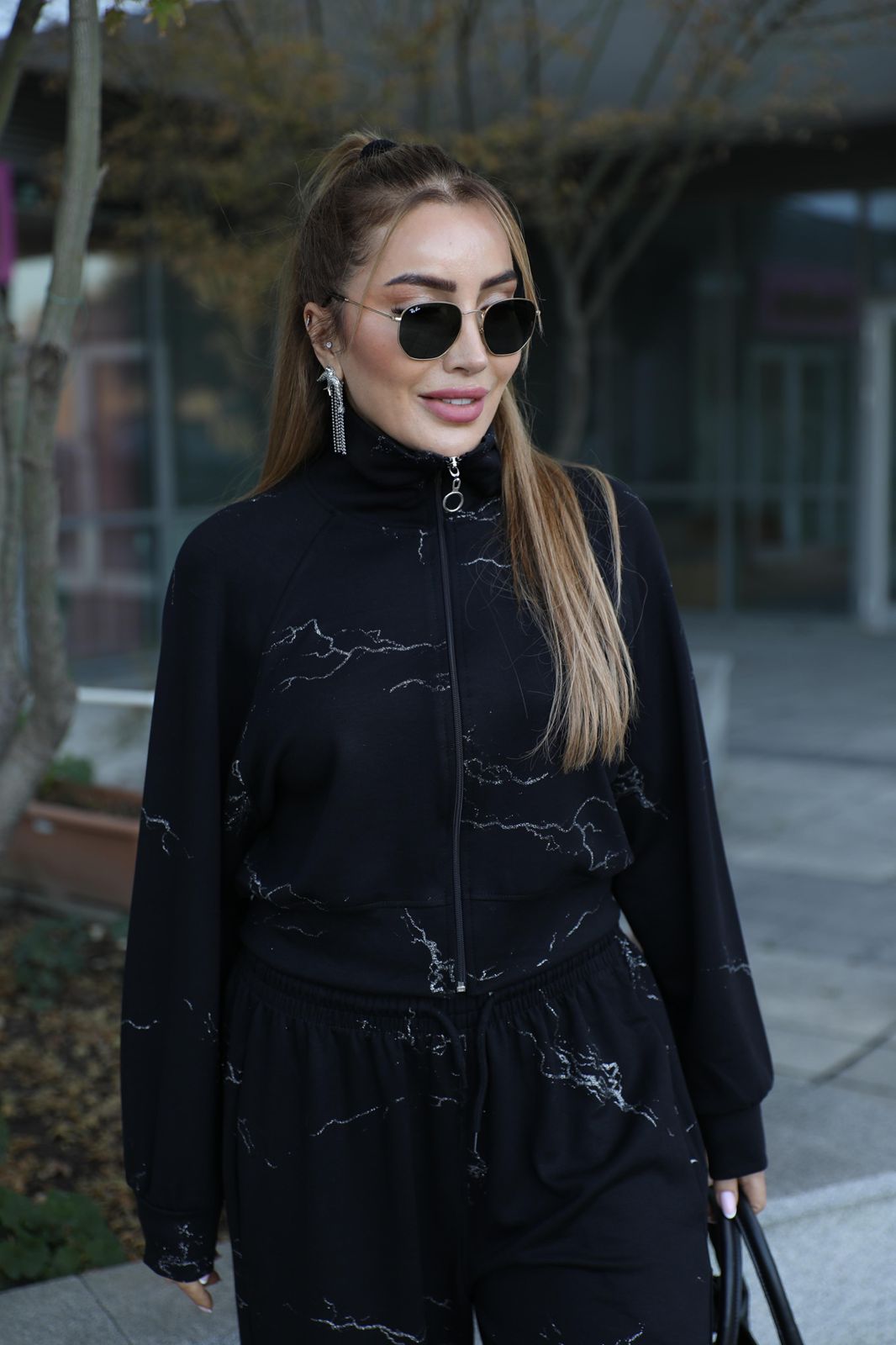 Black two-piece outfit: zip jacket and matching wide-leg pants with fine line graphics
