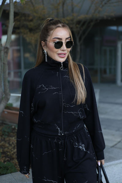 Black two-piece outfit: zip jacket and matching wide-leg pants with fine line graphics